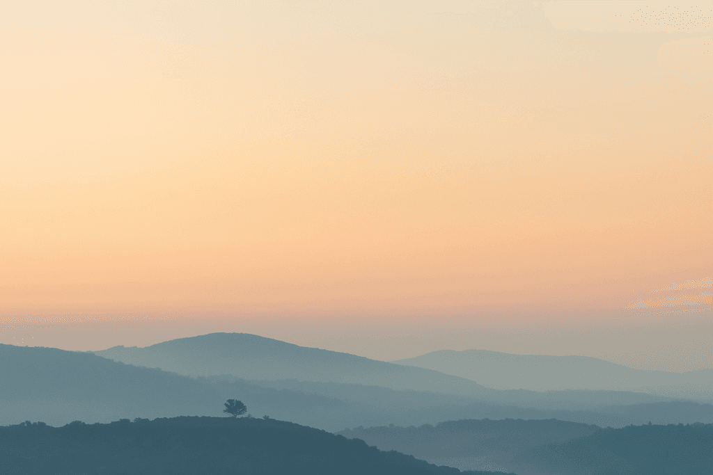 Deus. Paisagem natural ao amanhecer com névoa suave e luz dourada, representando a paz e o silêncio onde Deus fala ao coração.